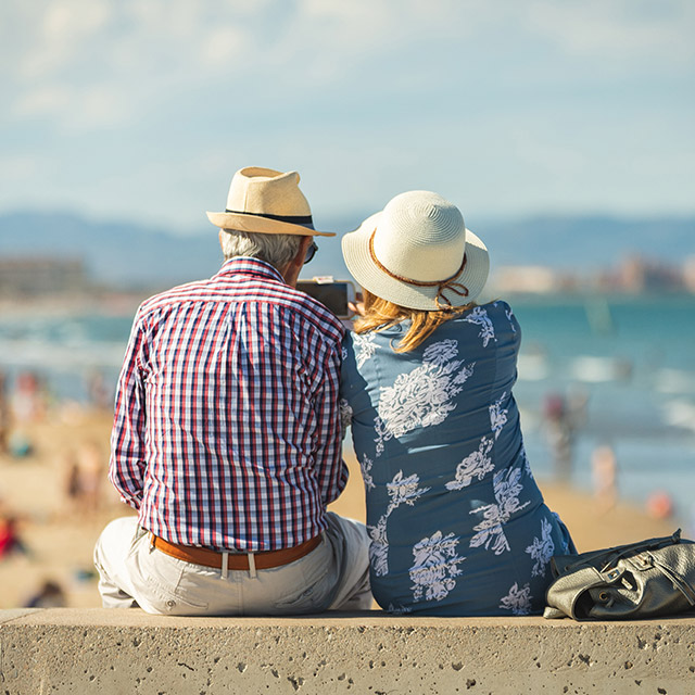 Older couple using a mobile phone at the beach
