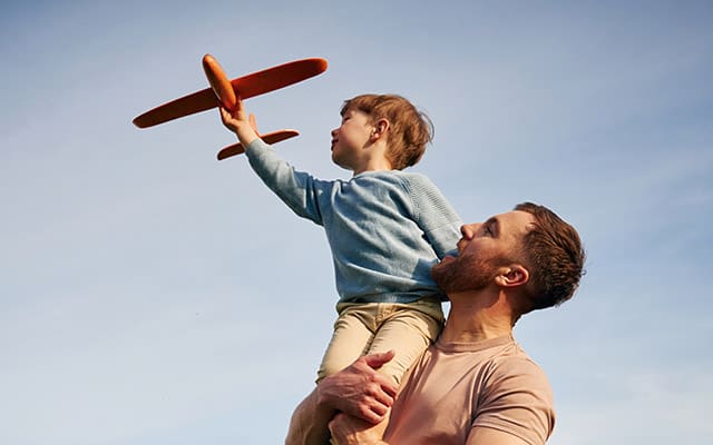 Dad and son flying toy aeroplane