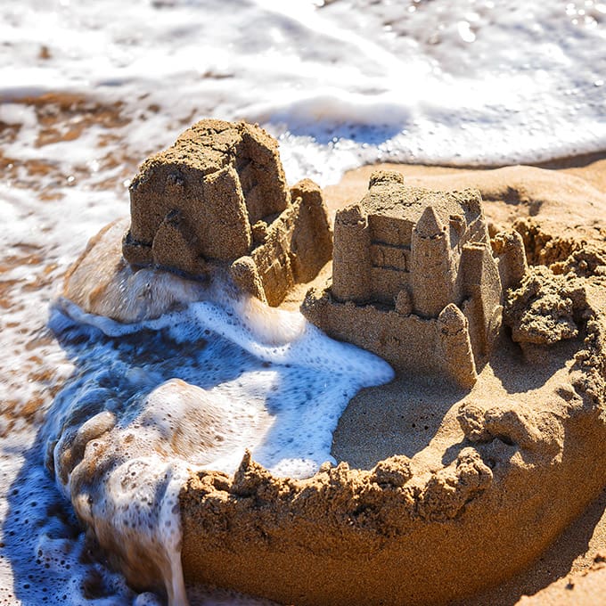 Sand castle being washed by small waves
