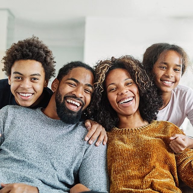 Family with teen age children posing for photo in lounge