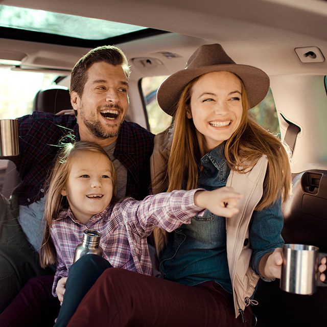 Young family with one daughter watching a show from inside a vehicle