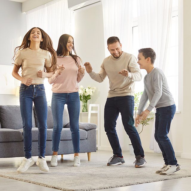 Young family dancing in clean bright lounge