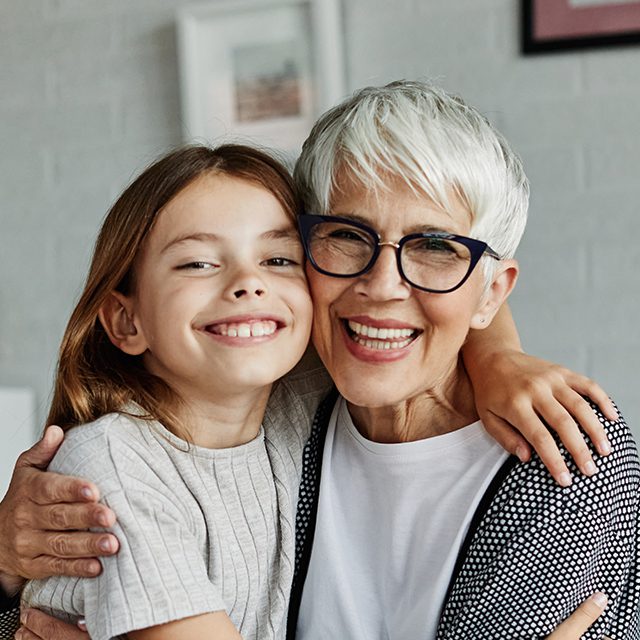 Portrait of Grandmother and granddaughter or daughter having fun hugging and bonding together at home